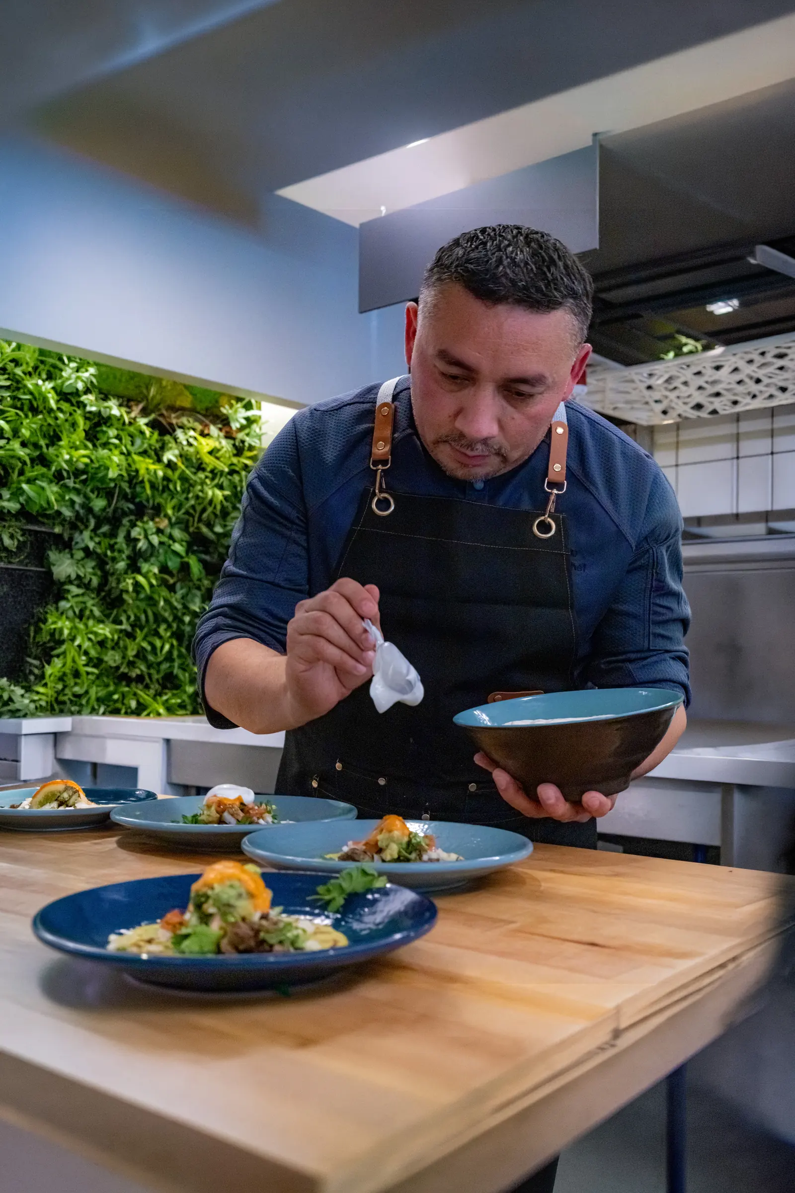 Chef Santos Lugo finishing each plate by hand, with the calm detail expected of private and executive service